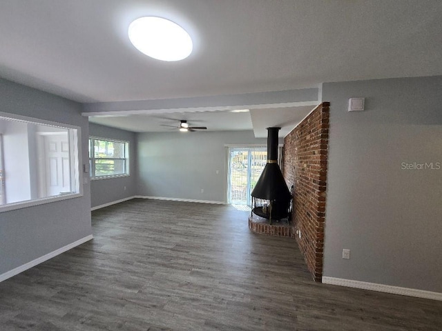 2827 SE 2nd St, Ocala, FL 34471 - unfurnished living room with baseboards, dark wood finished floors, a wood stove, and ceiling fan
