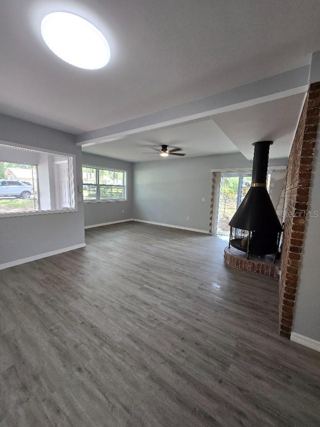 2827 SE 2nd St, Ocala, FL 34471 - unfurnished living room featuring baseboards, wood finished floors, and a wood stove
