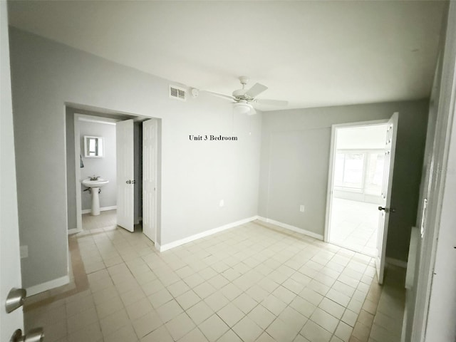 13228 3rd St E, Madeira Beach, FL 33708 - spare room featuring a ceiling fan, light tile patterned floors, and baseboards