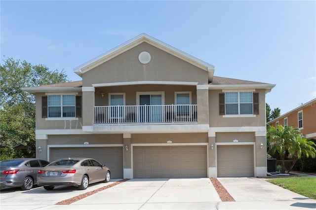 8409 Blue Rock Dr, New Port Richey, FL 34653 - view of property with stucco siding, concrete driveway, an attached garage, central air condition unit, and a balcony