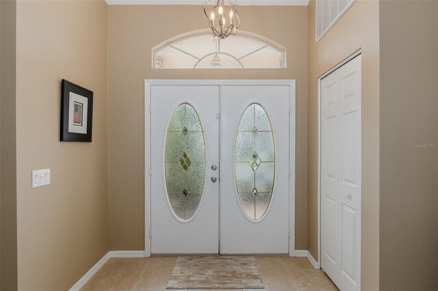 1105 Flora Vista St, New Port Richey, FL 34655 - entrance foyer featuring a chandelier, light tile patterned flooring, baseboards, and a high ceiling
