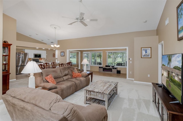 1105 Flora Vista St, New Port Richey, FL 34655 - living area with ceiling fan, light colored carpet, high vaulted ceiling, a chandelier, and baseboards