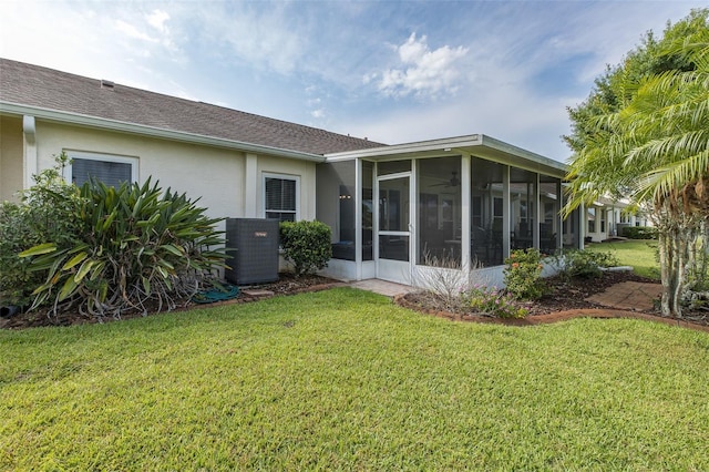 1105 Flora Vista St, New Port Richey, FL 34655 - back of property with a sunroom, central AC, stucco siding, a yard, and a shingled roof