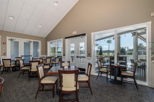 1105 Flora Vista St, New Port Richey, FL 34655 - dining room with french doors, dark colored carpet, healthy amount of natural light, and high vaulted ceiling