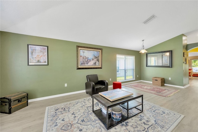 1009 Summer Breeze Dr, Brandon, FL 33511 - living room featuring lofted ceiling, light wood-type flooring, baseboards, and arched walkways