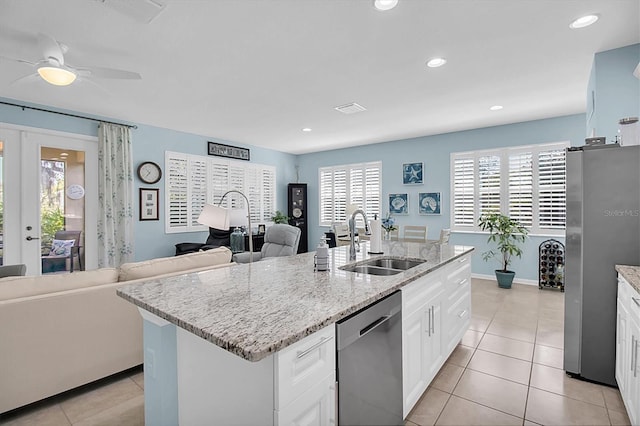11308 Mollymawk Ct, New Port Richey, FL 34654 - kitchen with a sink, appliances with stainless steel finishes, a center island with sink, light tile patterned flooring, and white cabinets