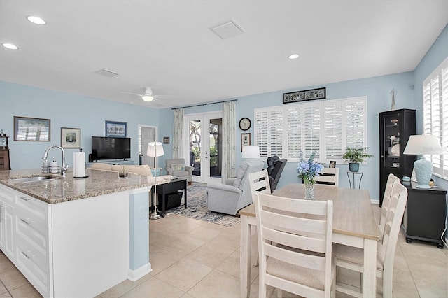 11308 Mollymawk Ct, New Port Richey, FL 34654 - kitchen featuring a sink, french doors, white cabinets, light tile patterned floors, and healthy amount of natural light