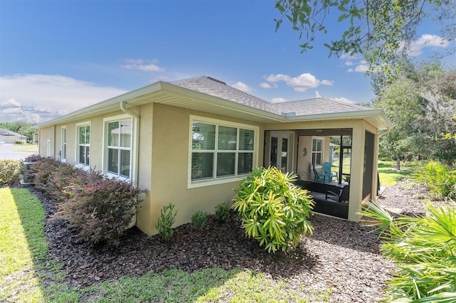 11308 Mollymawk Ct, New Port Richey, FL 34654 - view of side of property with stucco siding, a sunroom, and roof with shingles