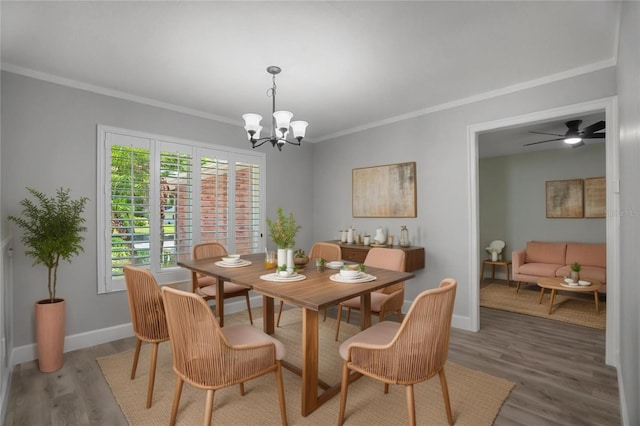 2866 Thistle Ct N, Palm Harbor, FL 34684 - dining room with light wood finished floors, a chandelier, crown molding, baseboards, and a ceiling fan