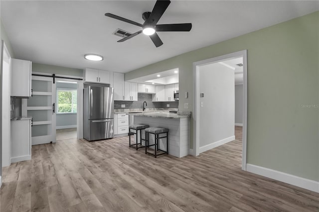 2866 Thistle Ct N, Palm Harbor, FL 34684 - kitchen featuring appliances with stainless steel finishes, white cabinetry, baseboards, ceiling fan, and a peninsula