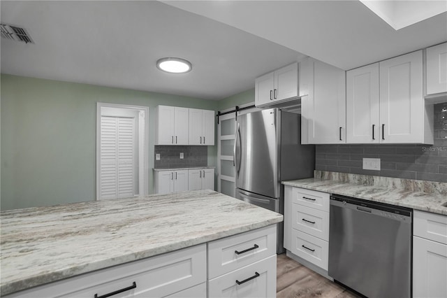 2866 Thistle Ct N, Palm Harbor, FL 34684 - kitchen featuring stainless steel appliances, white cabinetry, and backsplash