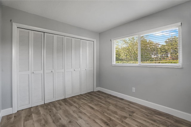 2866 Thistle Ct N, Palm Harbor, FL 34684 - unfurnished bedroom with baseboards, wood finished floors, and a closet