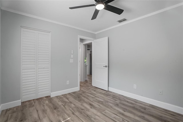 2866 Thistle Ct N, Palm Harbor, FL 34684 - unfurnished bedroom with crown molding, baseboards, wood finished floors, a closet, and a ceiling fan