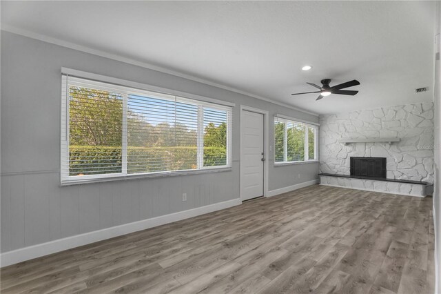2866 Thistle Ct N, Palm Harbor, FL 34684 - unfurnished living room featuring ceiling fan, wood finished floors, a fireplace, baseboards, and ornamental molding