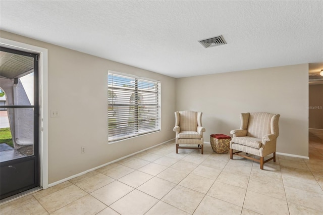 4424 Whitetail Ln, New Port Richey, FL 34653 - living area featuring a textured ceiling, light tile patterned floors, and baseboards