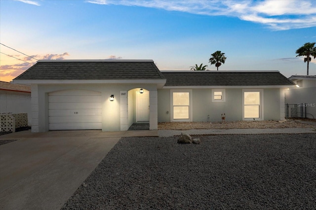 3907 Headsail Dr, New Port Richey, FL 34652 - view of front of home featuring mansard roof, roof with shingles, an attached garage, concrete driveway, and stucco siding