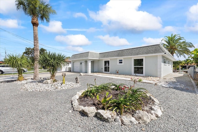 3907 Headsail Dr, New Port Richey, FL 34652 - view of front property with an attached garage, a shingled roof, mansard roof, and stucco siding