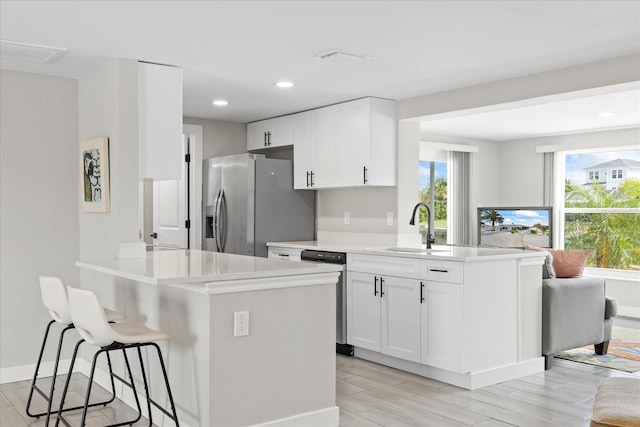 3907 Headsail Dr, New Port Richey, FL 34652 - kitchen with stainless steel appliances, a peninsula, a breakfast bar, light countertops, and recessed lighting