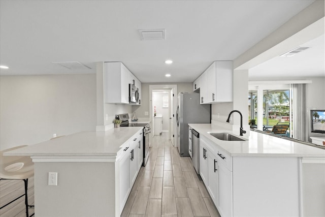 3907 Headsail Dr, New Port Richey, FL 34652 - kitchen with stainless steel appliances, a peninsula, recessed lighting, a kitchen breakfast bar, and light countertops