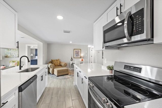 3907 Headsail Dr, New Port Richey, FL 34652 - kitchen with appliances with stainless steel finishes, light countertops, white cabinets, and recessed lighting