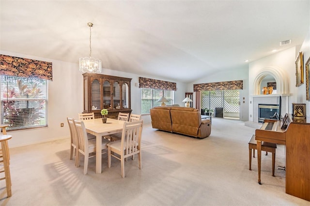 1407 Hickory Moss Pl, Trinity, FL 34655 - dining space with vaulted ceiling, light carpet, a chandelier, a glass covered fireplace, and baseboards