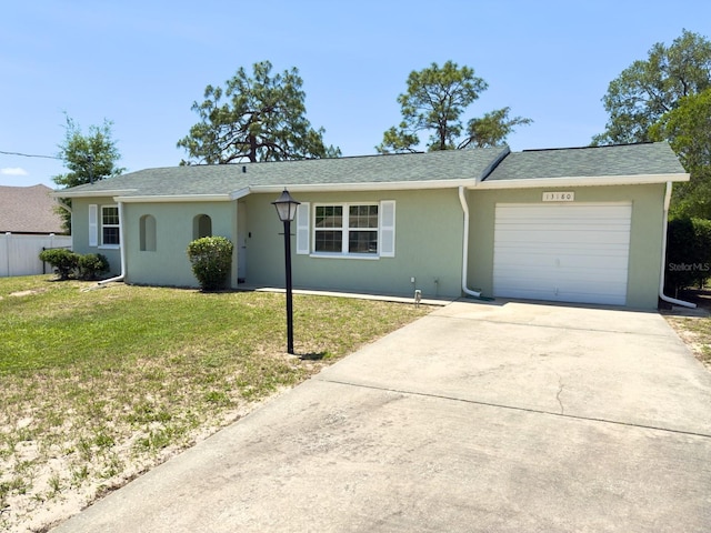 13180 Lawrence St, Spring Hill, FL 34609 - single story home with a garage, a front yard, stucco siding, and driveway