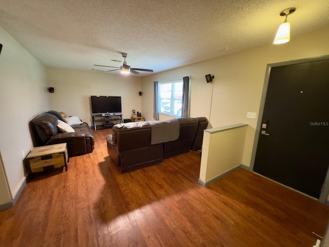 13180 Lawrence St, Spring Hill, FL 34609 - living room featuring wood finished floors, a textured ceiling, ceiling fan, and baseboards