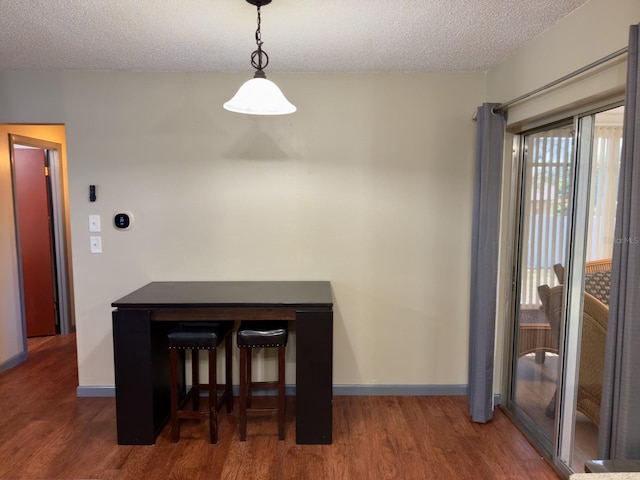 13180 Lawrence St, Spring Hill, FL 34609 - dining space with a textured ceiling, wood finished floors, and baseboards