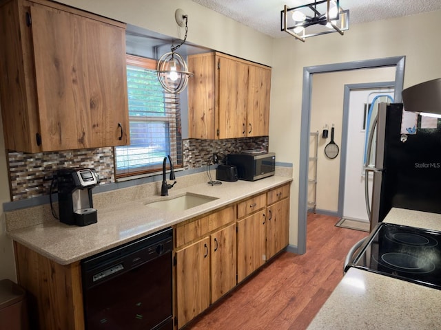 13180 Lawrence St, Spring Hill, FL 34609 - kitchen with black appliances, a sink, decorative backsplash, light wood-type flooring, and light countertops