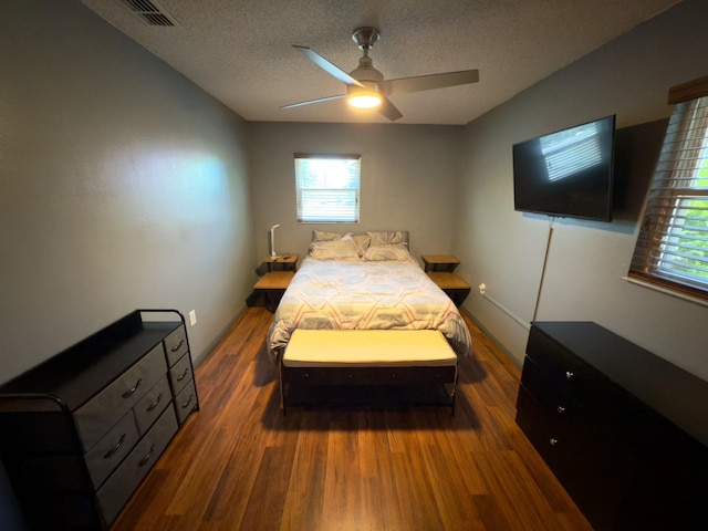 13180 Lawrence St, Spring Hill, FL 34609 - bedroom with wood finished floors, a textured ceiling, multiple windows, and ceiling fan