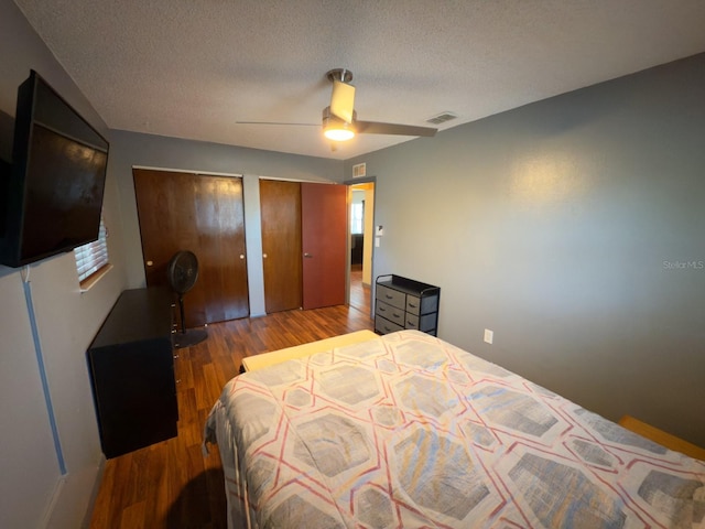 13180 Lawrence St, Spring Hill, FL 34609 - bedroom featuring wood finished floors, two closets, a textured ceiling, and a ceiling fan