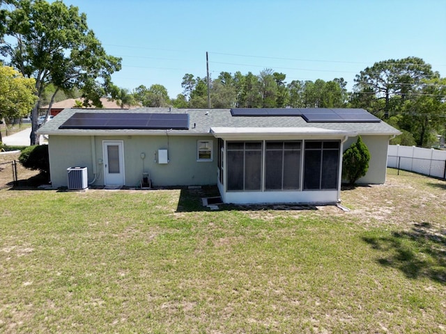 13180 Lawrence St, Spring Hill, FL 34609 - rear view of house featuring a sunroom, cooling unit, solar panels, and stucco siding