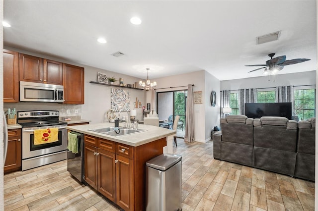 1108 Blackwater Dr, Wesley Chapel, FL 33543 - kitchen with stainless steel appliances, a sink, light wood-style flooring, a chandelier, and recessed lighting