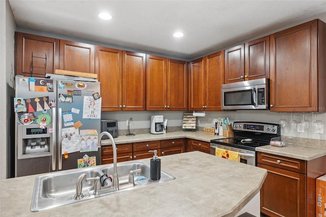 1108 Blackwater Dr, Wesley Chapel, FL 33543 - kitchen featuring appliances with stainless steel finishes, light countertops, a sink, recessed lighting, and brown cabinets