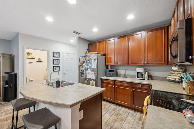 1108 Blackwater Dr, Wesley Chapel, FL 33543 - kitchen featuring stainless steel appliances, a sink, light wood-style floors, light countertops, and a breakfast bar area