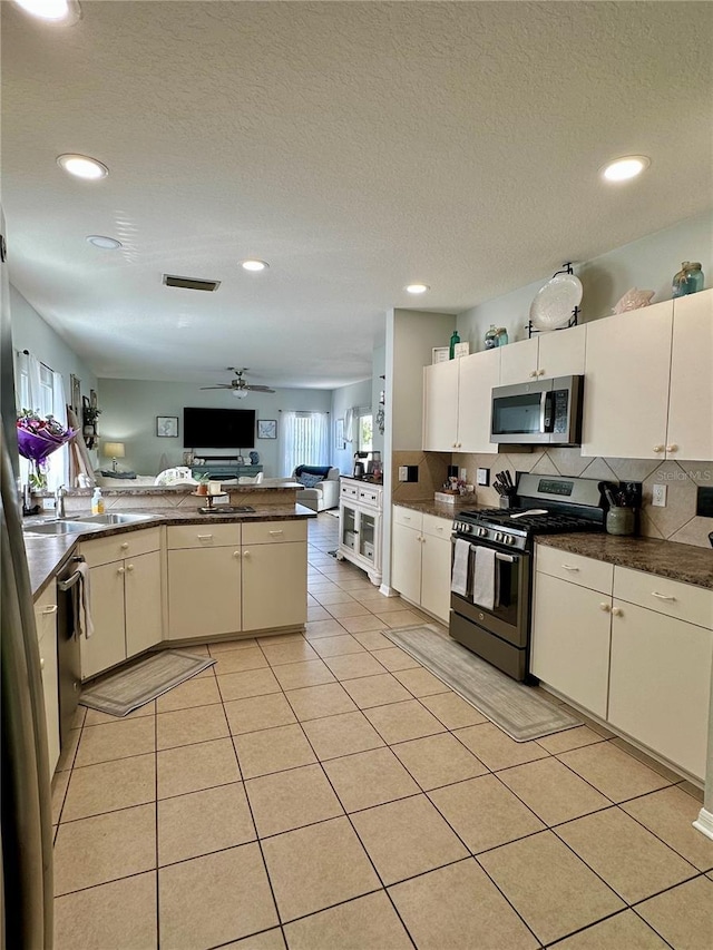 9808 Riverchase Dr, New Port Richey, FL 34655 - kitchen with stainless steel appliances, open floor plan, dark countertops, recessed lighting, and a sink