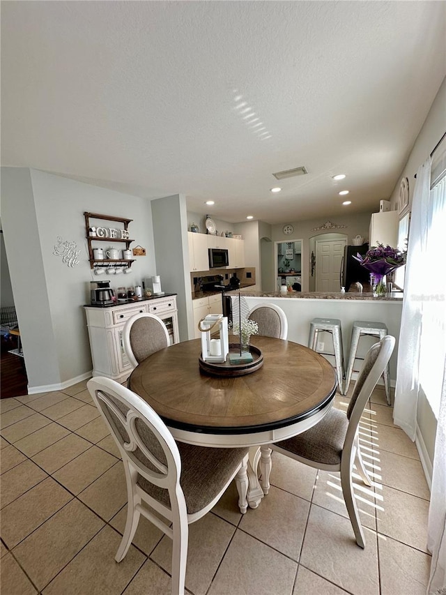 9808 Riverchase Dr, New Port Richey, FL 34655 - dining space featuring light tile patterned flooring, a textured ceiling, baseboards, and recessed lighting