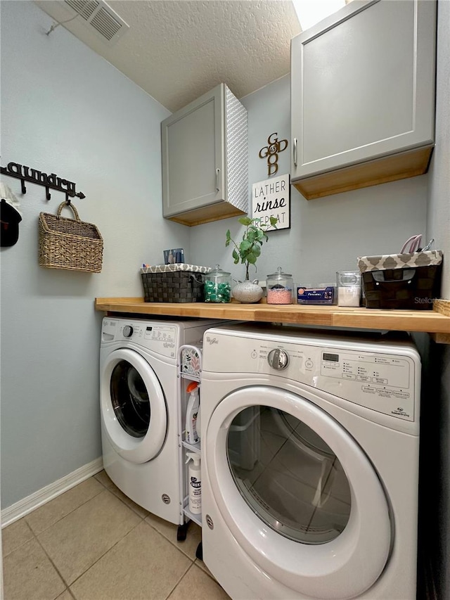 9808 Riverchase Dr, New Port Richey, FL 34655 - laundry area with separate washer and dryer, cabinet space, light tile patterned floors, baseboards, and a textured ceiling