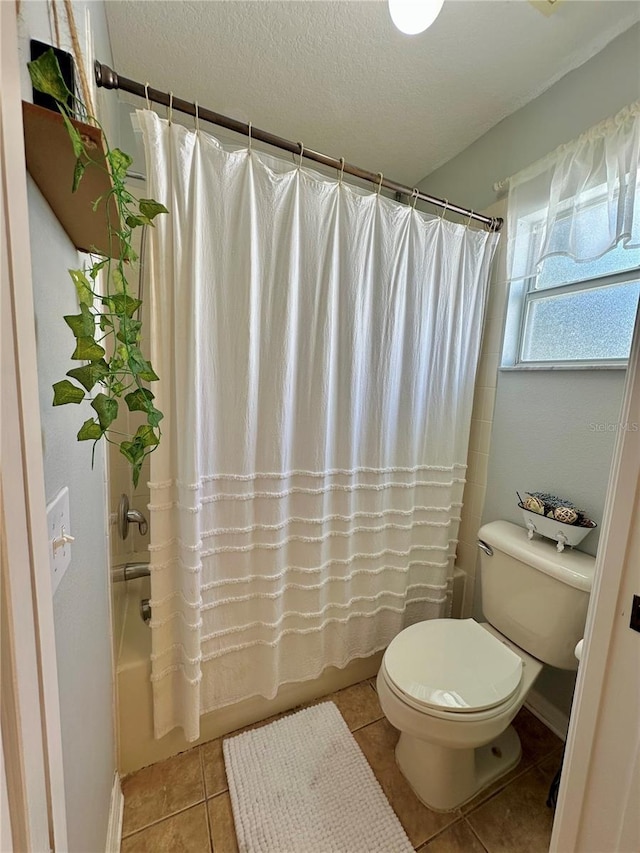 9808 Riverchase Dr, New Port Richey, FL 34655 - bathroom featuring shower / bath combo with shower curtain, toilet, tile patterned floors, a textured ceiling, and baseboards