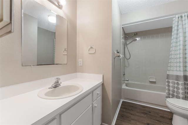 full bath with wood finished floors, toilet, vanity, shower / bath combination with curtain, and a textured ceiling
