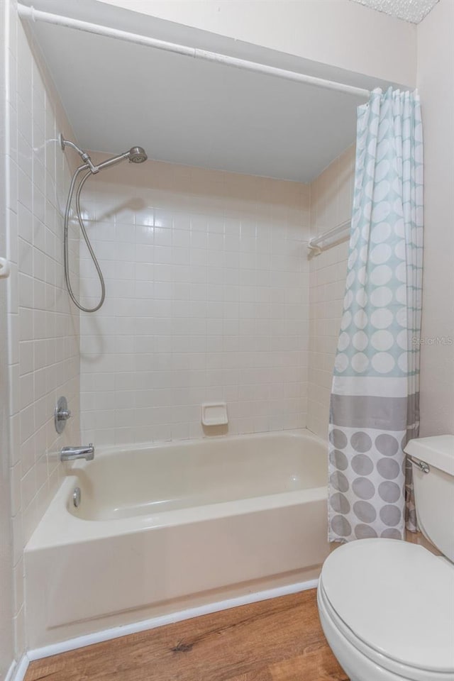 full bath featuring toilet, shower / bath combination with curtain, and wood finished floors
