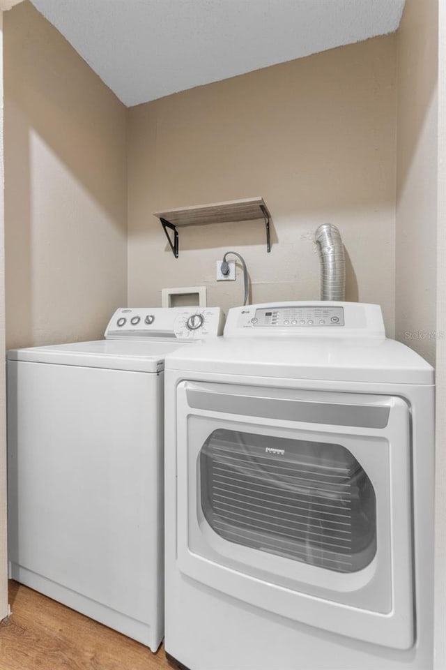 washroom with separate washer and dryer and light wood-style flooring