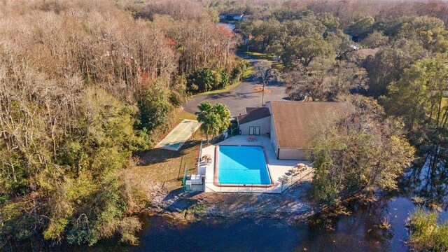 view from above of property featuring a forest and a pool area