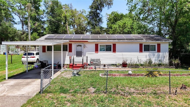 ranch-style home featuring solar panels, concrete driveway, a gate, and a carport