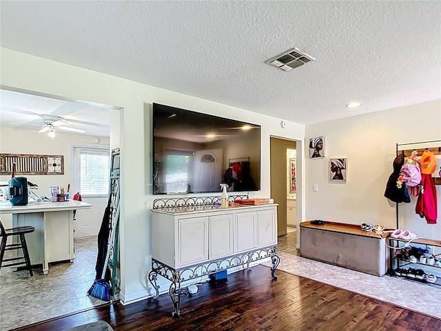 living area with wood finished floors, a textured ceiling, ceiling fan, baseboards, and recessed lighting