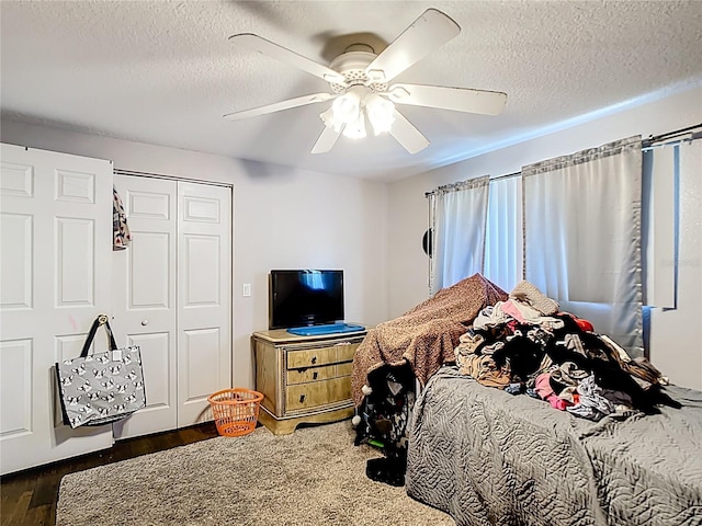 bedroom featuring wood finished floors, a textured ceiling, a closet, and a ceiling fan