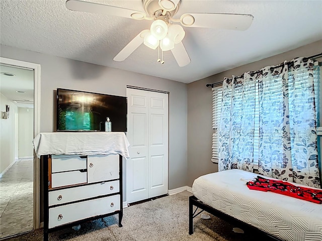 bedroom featuring baseboards, a ceiling fan, a closet, and carpet floors