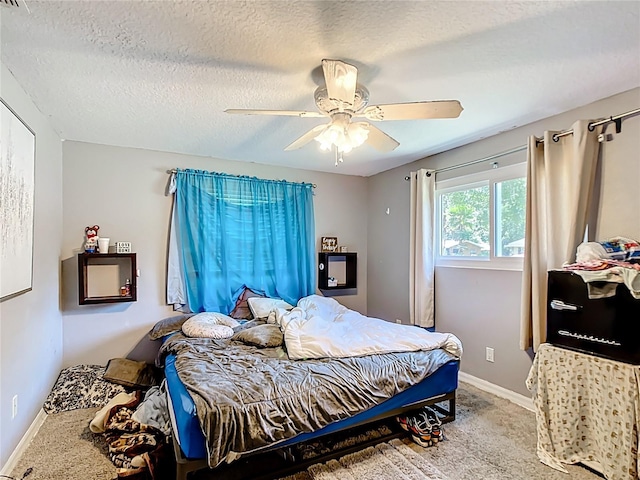 bedroom featuring ceiling fan, carpet, a textured ceiling, and baseboards