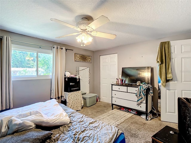 bedroom featuring a textured ceiling, carpet, and ceiling fan