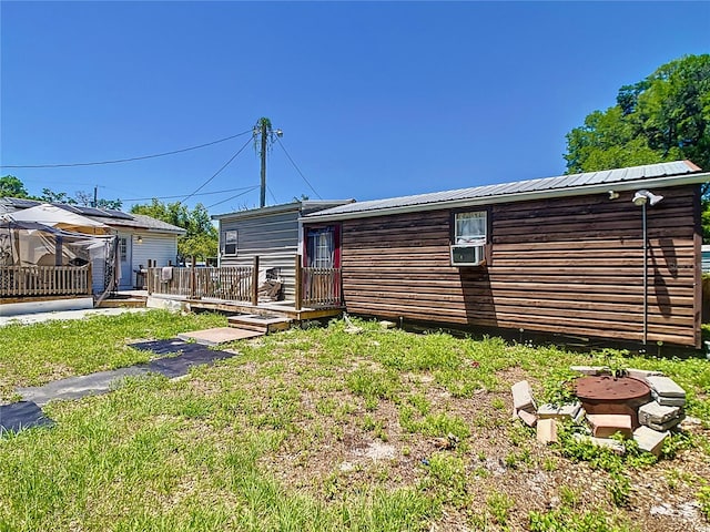 back of house featuring a deck, metal roof, and a yard